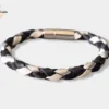 Un bracelet noir et blanc en cuir avec des crins de poney