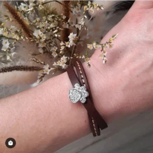Une femme qui porte un bracelet en cuir personnalisable avec une patte de chien