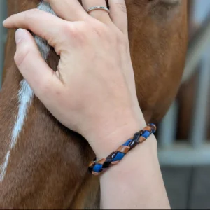 Un cheval et sa propriétaire qui porte un bracelet en cuir avec ses crins