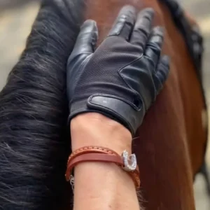 Une cavalière avec un bracelet en cuir orné d'un fer à cheval