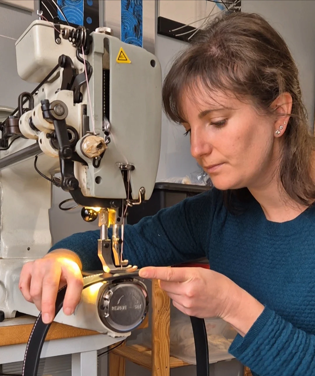 Une artisane sellier harnacheur qui coud du cuir à la machine à coudre
