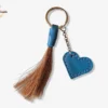 Un porte clé en cuir bleu avec des crins de cheval